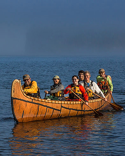 happy group canoeing a big canoe