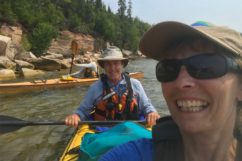 woman and man taking a selfie in a two person kayak