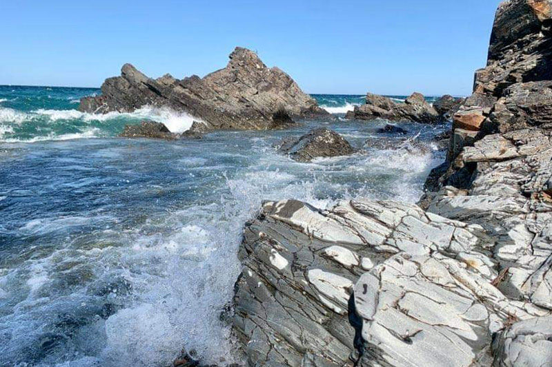 waves crashing against sharp rocky shore
